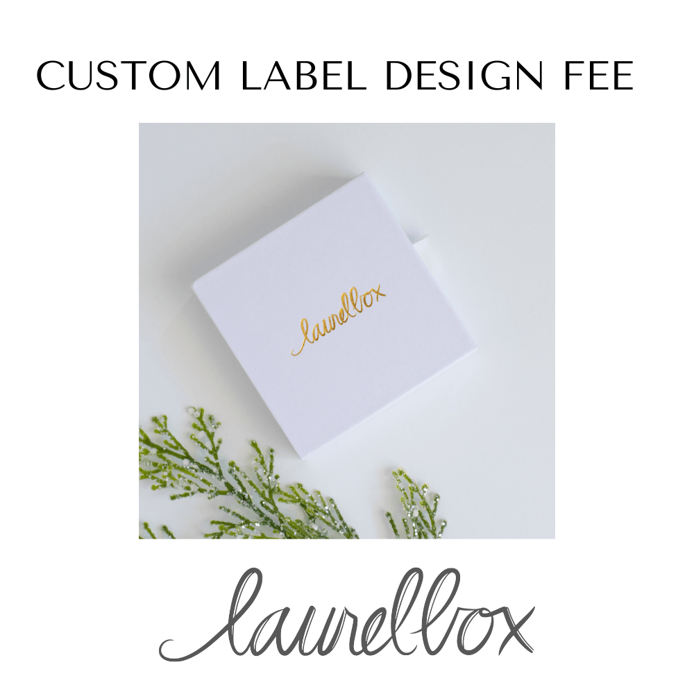 Custom Label Design Fee in gold text on a white cube, surrounded by green foliage, for a remembrance gift.