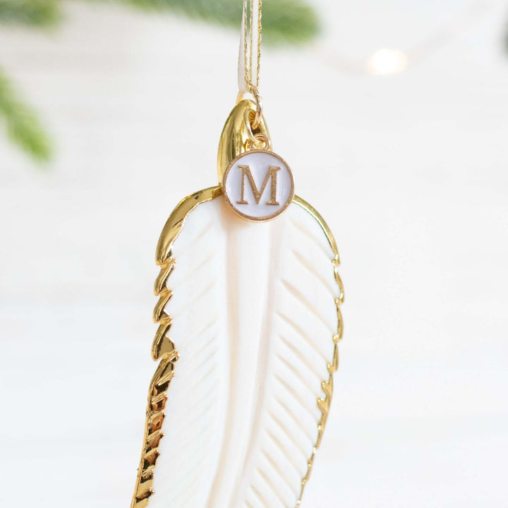 In Memory Feather Ornament features a white feather with gold accents and a circular tag marked &