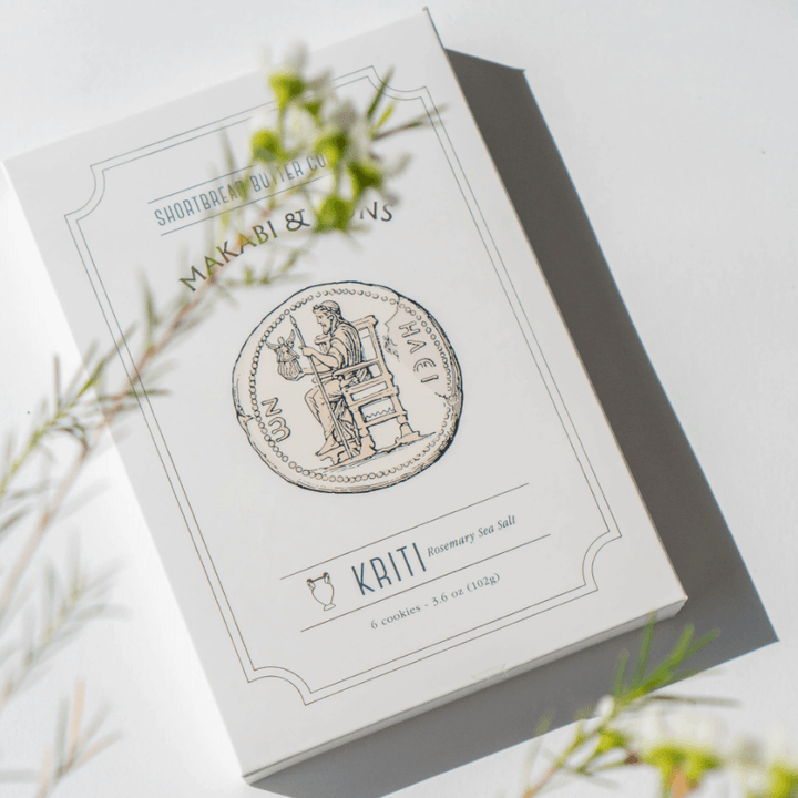 Packaging for Shortbread Rosemary and Sea Salt Cookies, featuring a coin design and text on a white box.